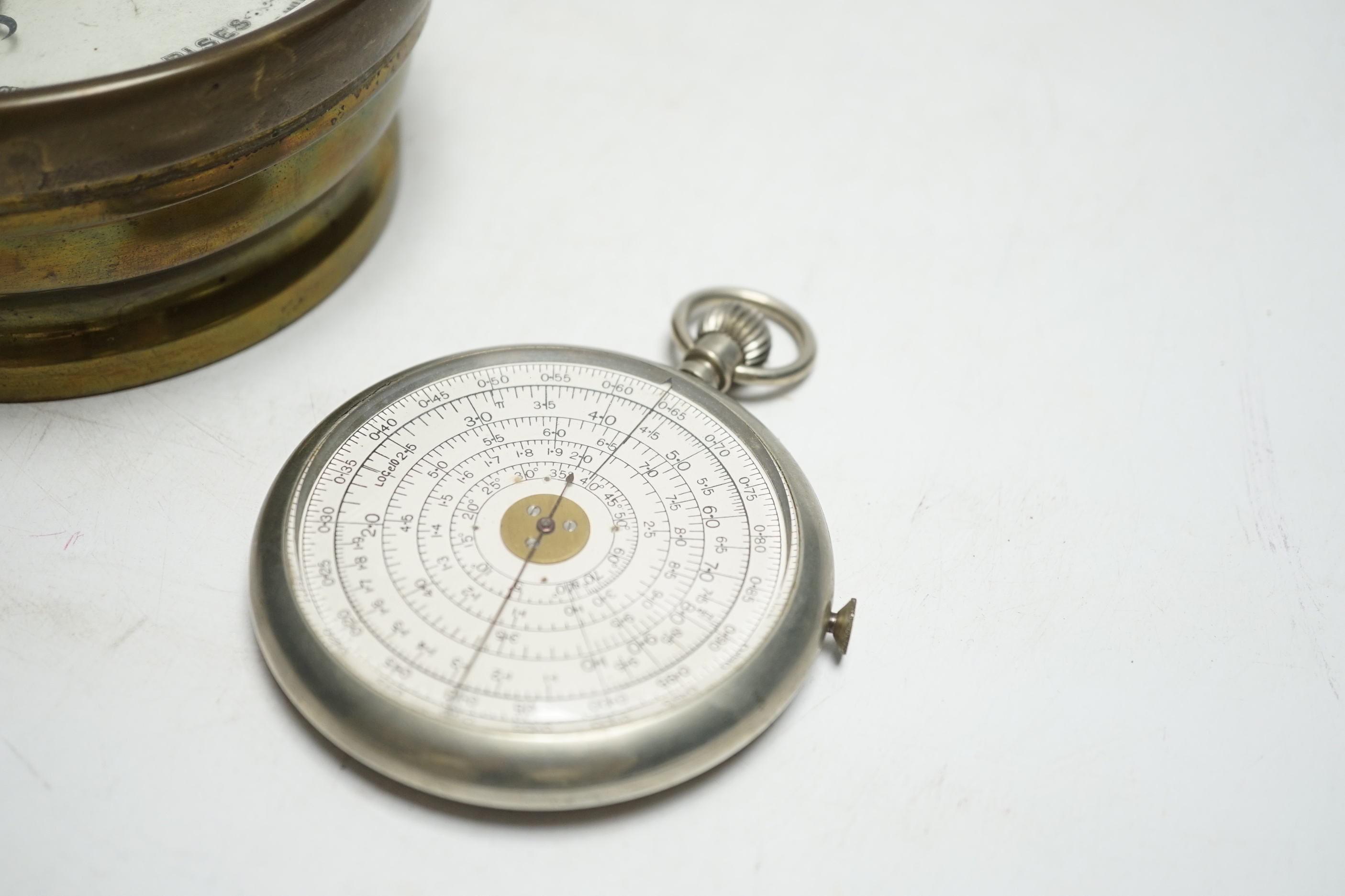 An aneroid barometer and a pocket calculator, calculator 11cm high